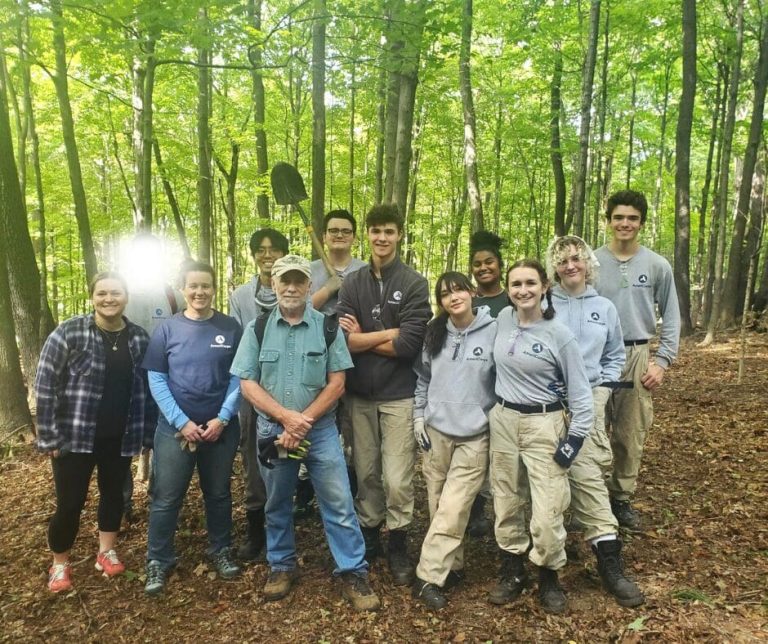 A group of Americorp members in the woods posing for a photo
