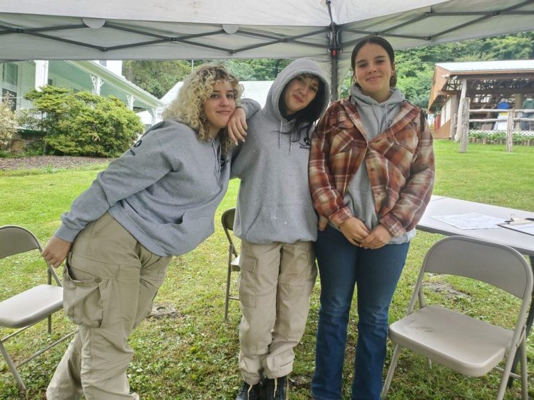 Americorp members posing for a photo under a tent